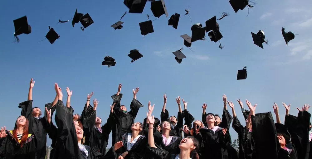 College students at graduation throwing their caps into the air