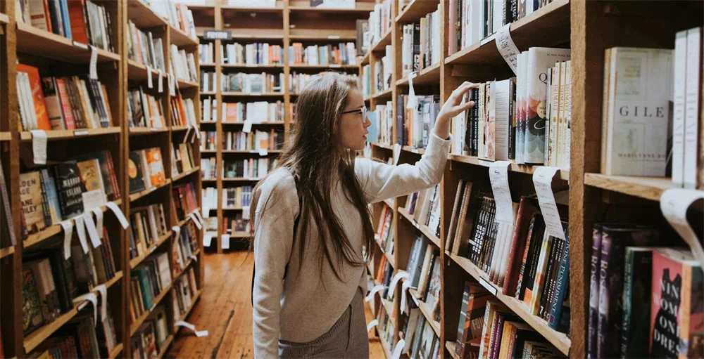 woman in college library looking at books