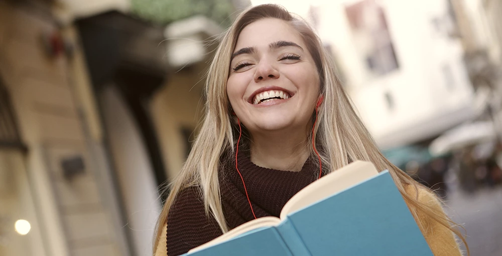 smiling student holding a book about financial literacy