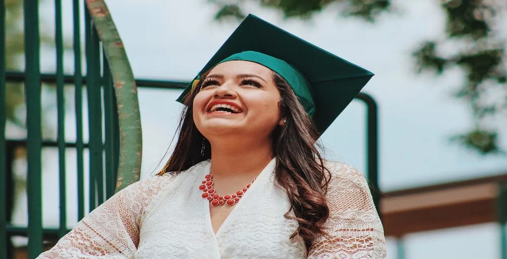 Woman at college graduation smiling wearing cap