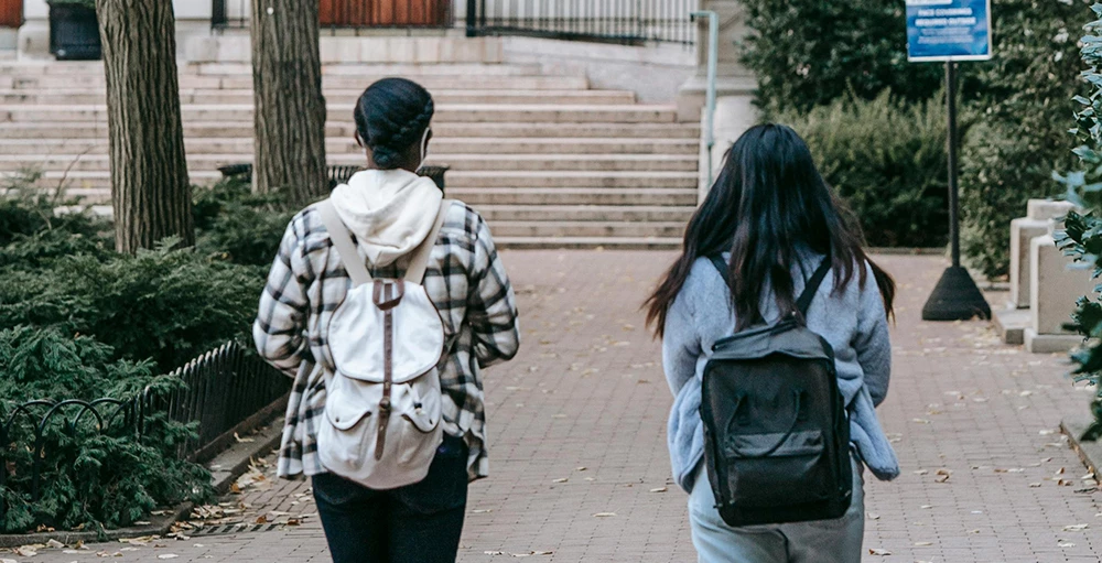 college students walking along paved pathway