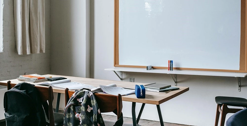 desk with notebooks and backpacks in classroom