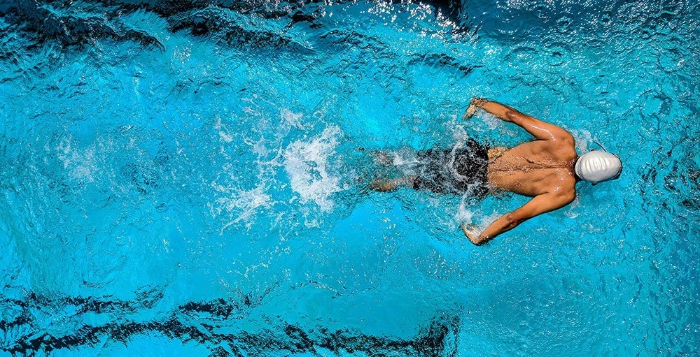 student-athlete swimming in pool