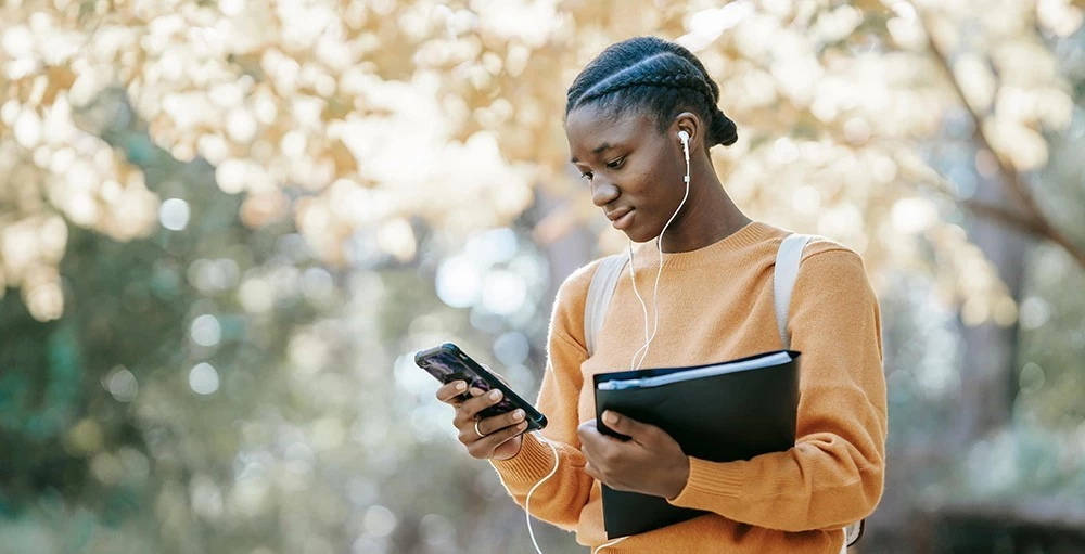 college student listening to music using smartphone on campus