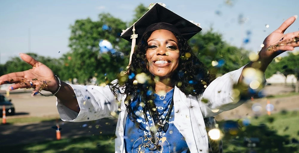 woman with graduation cap throwing confetti