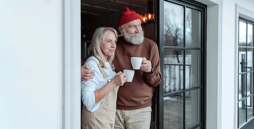 couple holding coffee mugs and enjoying early retirement